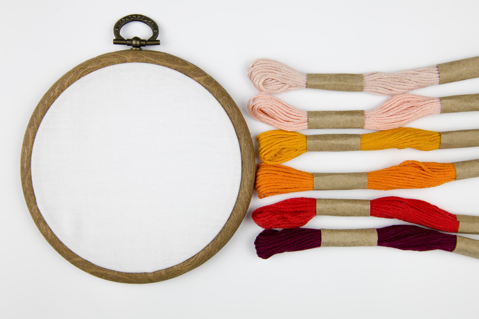 Close-up colorful embroidery hoop on linen fabric